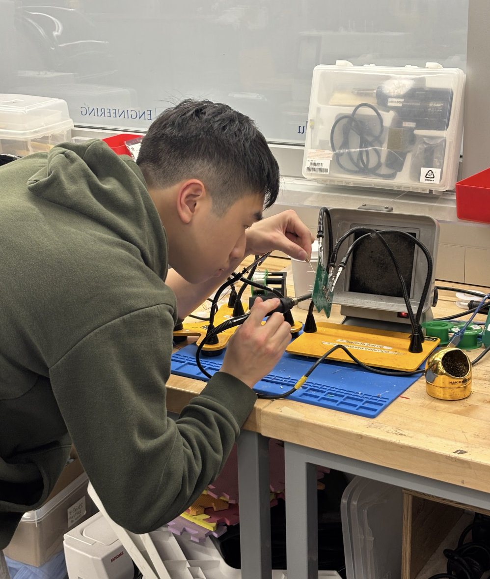 AQUAS team member soldering electronics for the water sampling payload